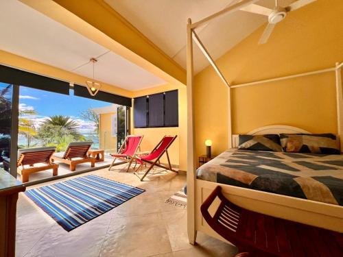 a bedroom with a bed and a balcony with chairs at Beach Villa Coco in Palmar