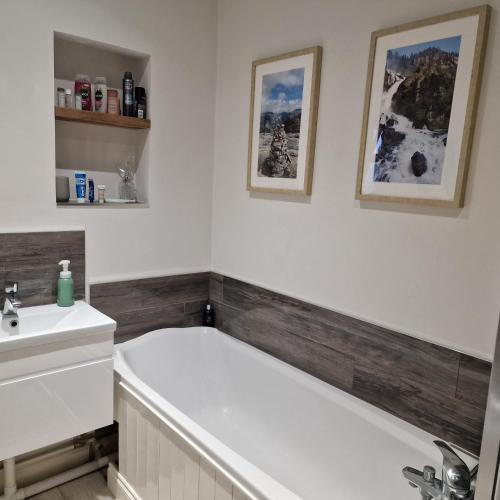 a bathroom with a bath tub and a sink at Family-Friendly Bungalow near Salisbury in Alderbury