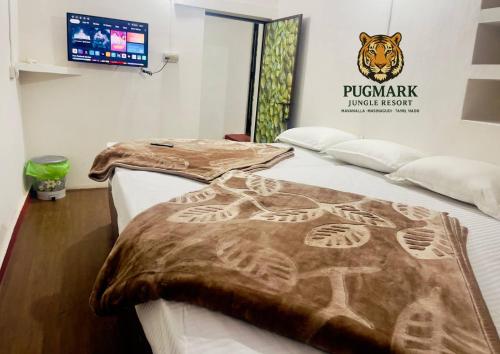 two beds in a room with a blanket on them at Pug Mark Jungle Resort - Masinagudi in Masinagudi