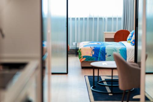 a bedroom with a bed and a table and a chair at Citadines Gongbei Zhuhai in Zhuhai