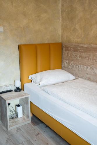 a bed with an orange headboard in a room at Haus Kärnten in Döbriach