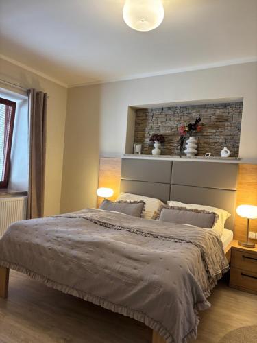 a bedroom with a large bed with two lamps at Penzion Apartmány Resident in Poděbrady
