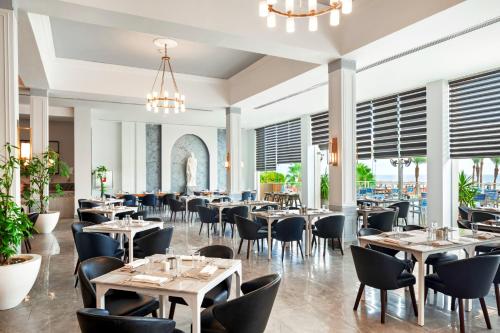 a dining room with tables and chairs and windows at Pickalbatros The Palace Port Ghalib in Port Ghalib