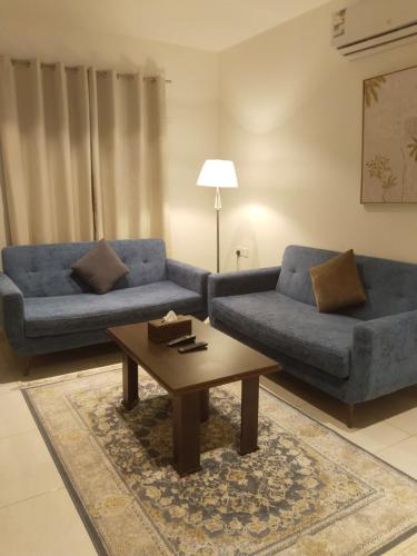 a living room with two blue couches and a coffee table at شقة فاخرة بغرفتين وحمامين وصالة جلوس وصالة طعام in Al Madinah
