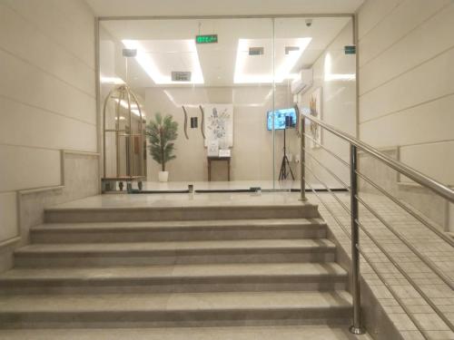 a hallway with stairs in a building with a camera at شقة فاخرة بغرفتين وحمامين وصالة جلوس وصالة طعام in Al Madinah