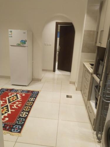 a room with a kitchen with a rug on the floor at شقة فاخرة بغرفتين وحمامين وصالة جلوس وصالة طعام in Al Madinah