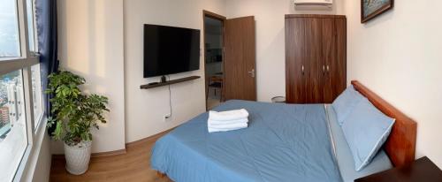 a bedroom with a blue bed and a flat screen tv at The Western Capital Apartment, Eric House in Ho Chi Minh City