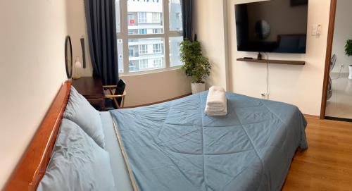 a bedroom with a bed with a blue comforter at The Western Capital Apartment, Eric House in Ho Chi Minh City