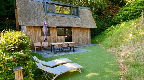 a house with a table and chairs in the yard at Park Heerehof in Schoorl