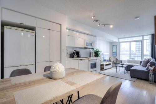 a kitchen and living room with a table and chairs at Modern 2 Bedroom plus Den Condo with Balcony Downtown Toronto in Toronto