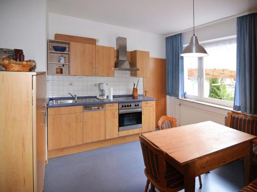 a kitchen with wooden cabinets and a wooden table with a wooden tableablish at Holiday farm situated next to the Kellerwald-Edersee national park with a sunbathing lawn in Bad Wildungen