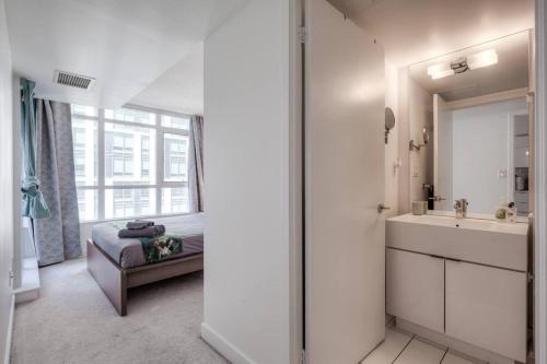 ein weißes Badezimmer mit Waschbecken und Spiegel in der Unterkunft Modern 3Br Condo with Balcony Downtown Toronto in Toronto