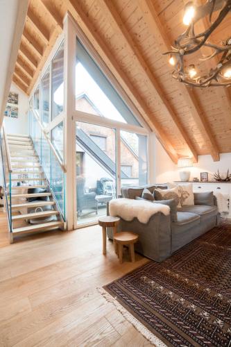 a living room with a couch and a large window at Swiss Family Chalet in Andermatt