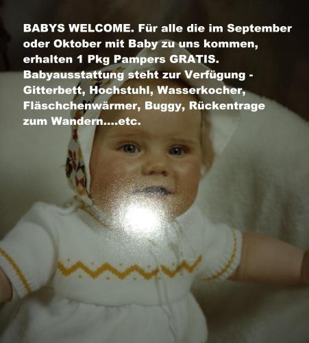 a baby dressed in white with glitter on its face at M4 Appartements in Wagrain