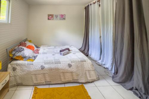 a bedroom with a bed with a quilt on it at Horizon Tropical - Avec piscine partagée in Sainte-Anne