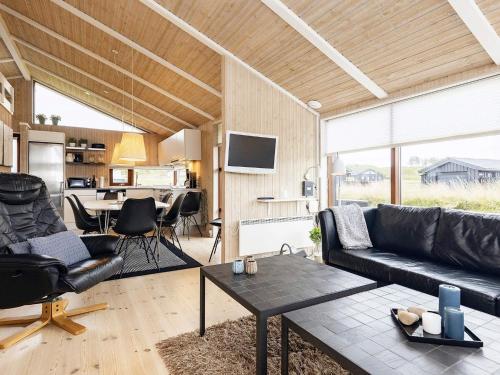 a living room with a couch and a table at 5 star holiday home in Hjørring in Lønstrup