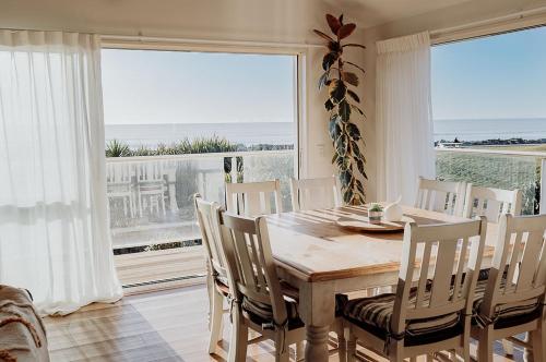 a dining room with a table and chairs and a large window at Sailor's Catch in Hokitika