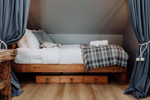a bed in a room with blue curtains at Sailor's Catch in Hokitika
