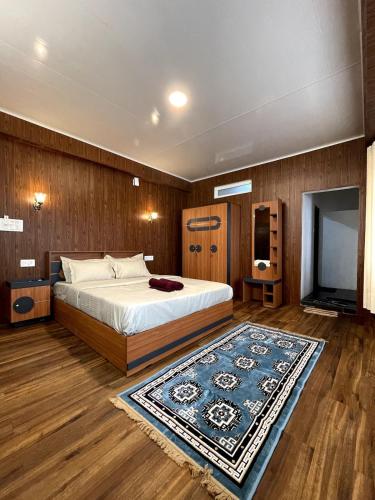 a bedroom with a bed and a flat screen tv at Lemos Cafe and Homestay in Kurseong