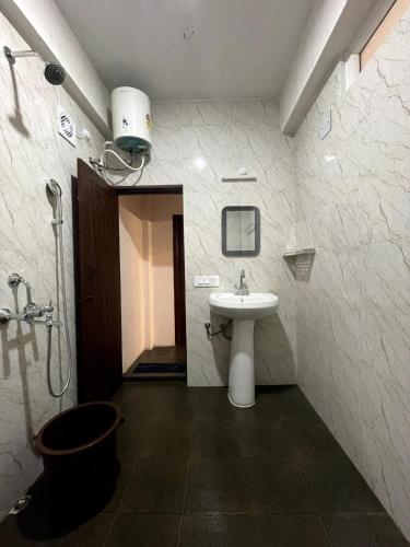a bathroom with a sink and a shower at Lemos Cafe and Homestay in Kurseong