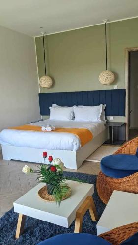 a bedroom with a bed and a table with flowers on it at Yvanka Appart City Antananarive in Antananarivo