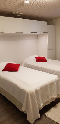 two beds with red pillows in a room at A1 Snow Angels Visit Levi in Levi
