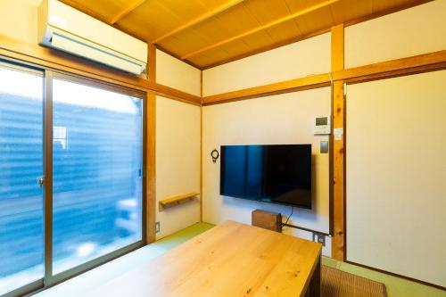 a room with a wooden table and a large window at Araiya Tokyo -Private Townhouse- in Tokyo
