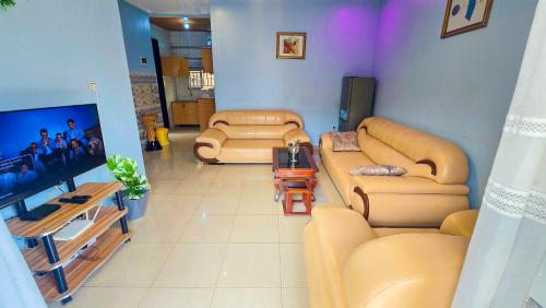 a living room with two couches and a flat screen tv at Gravity Suites in Taba
