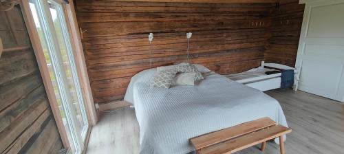 a bedroom with a bed in a wooden wall at Renstigen Evertsberg Vasaloppet in Älvdalen
