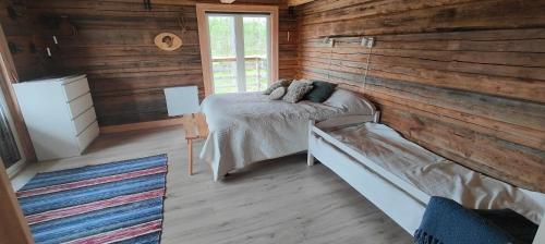 a bedroom with a bed and a wooden wall at Renstigen Evertsberg Vasaloppet in Älvdalen