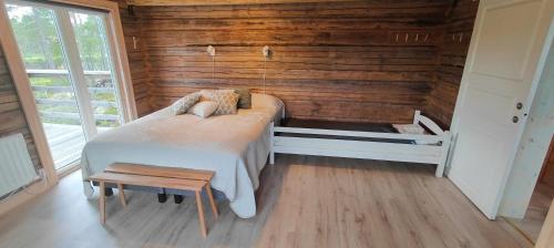 a bedroom with two beds in a wooden wall at Renstigen Evertsberg Vasaloppet in Älvdalen