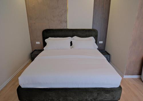 a bed with white sheets and pillows in a room at Hotel Valbor in Tropojë