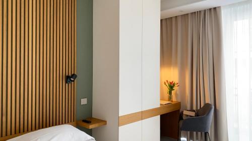 een slaapkamer met een bed, een bureau en een stoel bij ToSuite - Alba Moretta in Alba