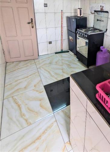a kitchen with marble floors and a door at Résidence PAIX et SERENITE in Douala