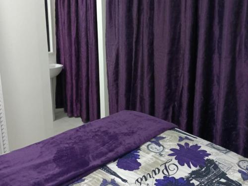 a bed with a purple blanket on top of it at Sarah's Place Guesthouse in Pretoria