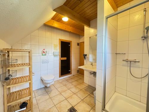 a bathroom with a shower and a toilet and a sink at Landgang 27 in Hemmoor