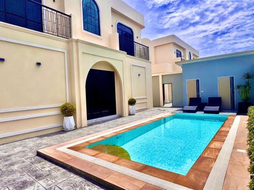 a villa with a swimming pool in front of a house at FLEX Pool Villa in Pattaya