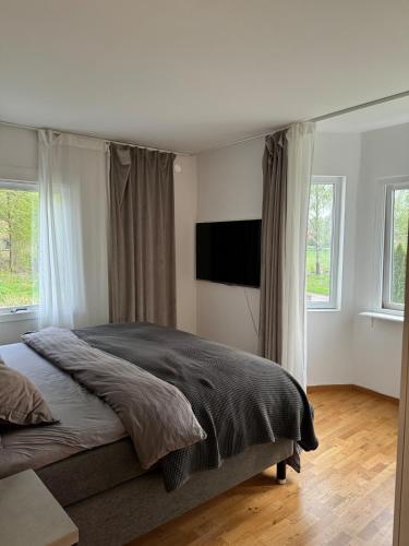 a bedroom with a bed and a flat screen tv at Fritids hus nära natur in Skärsnäs