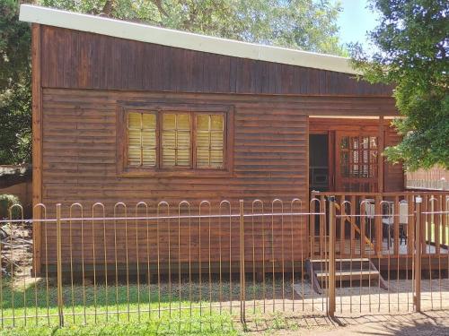 a small wooden house behind a fence at Sarah's Place Guesthouse in Pretoria