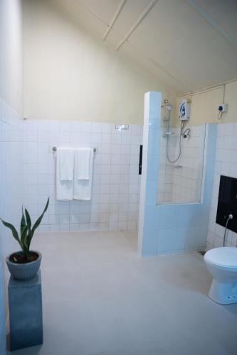 a bathroom with a toilet and a shower and a plant at Heritage Dambulla By Ceylon Hotels Corporation in Dambulla