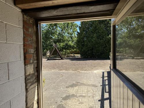 an open door of a building with a view at The Smythy Cotswolds Farm Stay With Pool in Lechlade