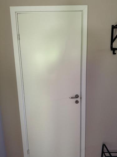 a white door with a silver handle in a room at Fritids hus nära natur in Skärsnäs