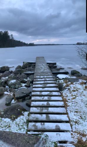 a wooden bridge over a body of water at Fritids hus nära natur in Skärsnäs