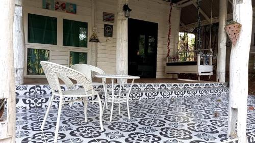 a patio with two chairs and a table on a porch at Phu Pha View Doi in Samoeng