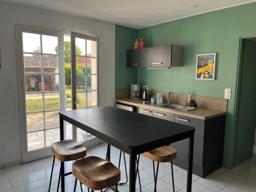 a kitchen with a black table and stools in it at Sérénité Marais-Océan in Longeville-sur-Mer