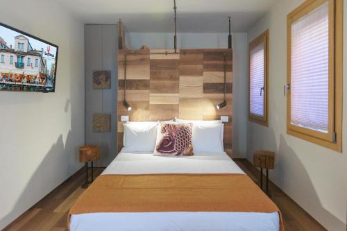 a bedroom with a large bed with a wooden headboard at LE RIVE Casa Vacanza La Ciosà in Chioggia