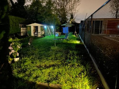 a yard lit up at night with a fence at Perk25A in Steenokkerzeel