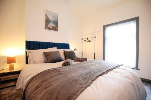a bedroom with a large bed with a dog laying on it at Dixon House, Sleeps 6, Free Parking, Long or Short Stays - by NMB Property in Horwich