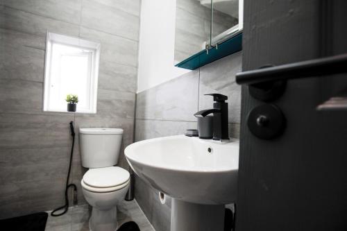 a bathroom with a white toilet and a sink at Dixon House, Sleeps 6, Free Parking, Long or Short Stays - by NMB Property in Horwich