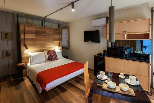 a hotel room with a bed and a table with cups on it at LE RIVE Guest House La Ciosà in Chioggia